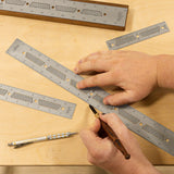 Hands using precision woodworking rulers and marking knife on a wood surface