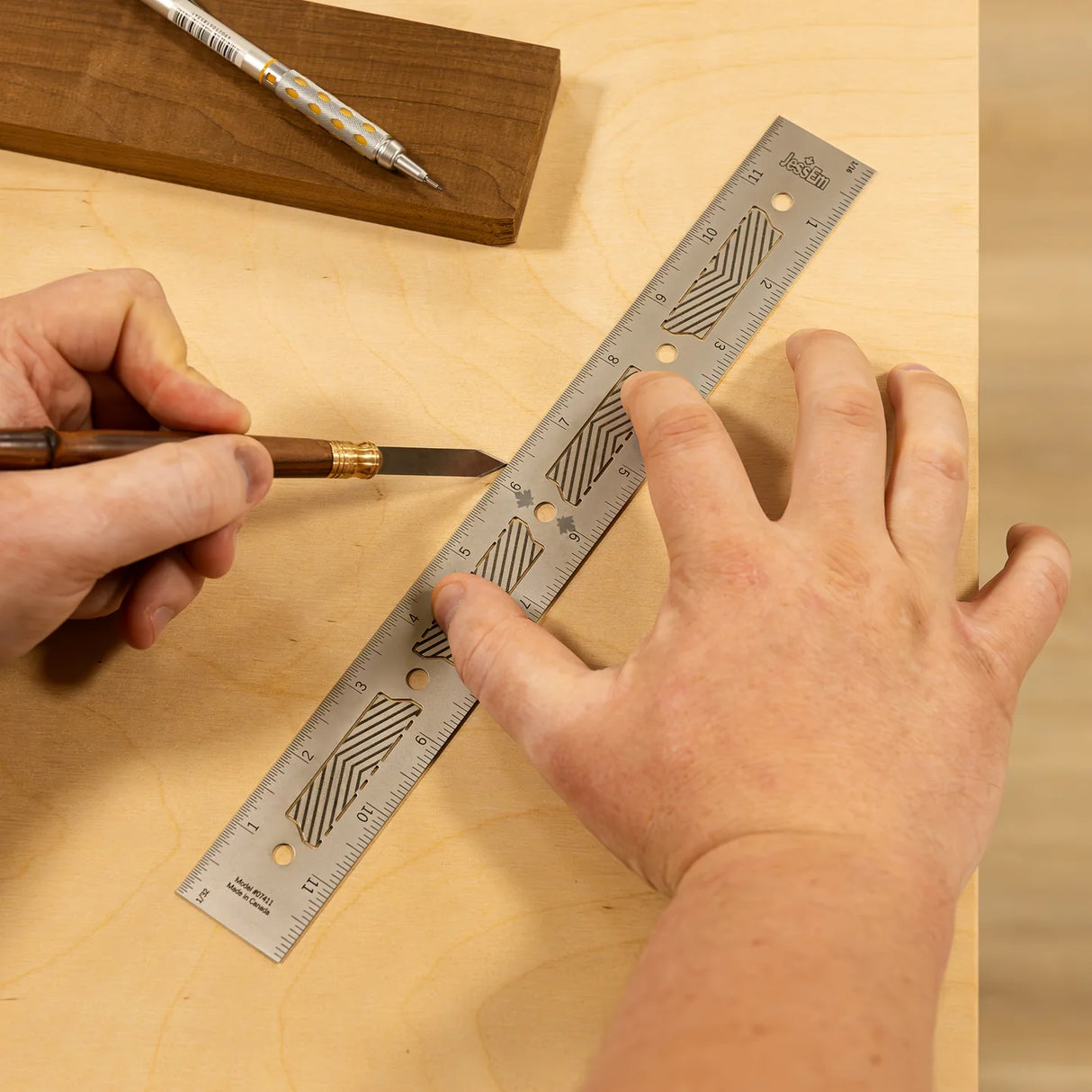 Marking wood with a precision steel ruler and marking knife on a workbench.