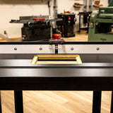 Router table with precision fence and insert plate in a woodworking workshop