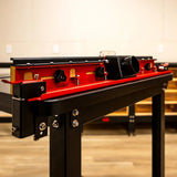 Red router table fence with dust port in a woodworking shop setting