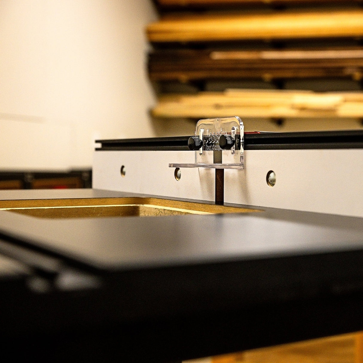 Router table fence with dust port and adjustable guard in woodworking shop setting