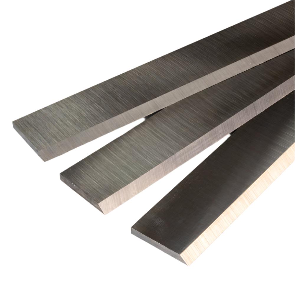 Set of industrial steel planer knives for woodworking, close-up on sharp blades