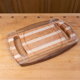 Wooden cutting board with finger groove handles on a workbench, woodworking tool accessory