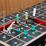 Woodworking bench with grid pattern, hold-down clamps, and green workbench accessories