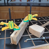 Woodworking bench with clamped board, mallet, and chisel for precision joinery