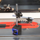 Magnetic base holder on a table saw, ideal for woodworking tool setup and blade alignment