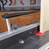 Woodworking router table setup with fence, measuring scale, and vertical push block in use
