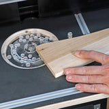 Woodworker guiding board over router table insert ring for precise edge routing