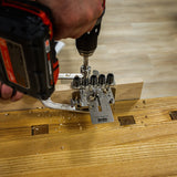 Drilling precise dowel holes in wood with a drill guide jig and cordless drill on workbench