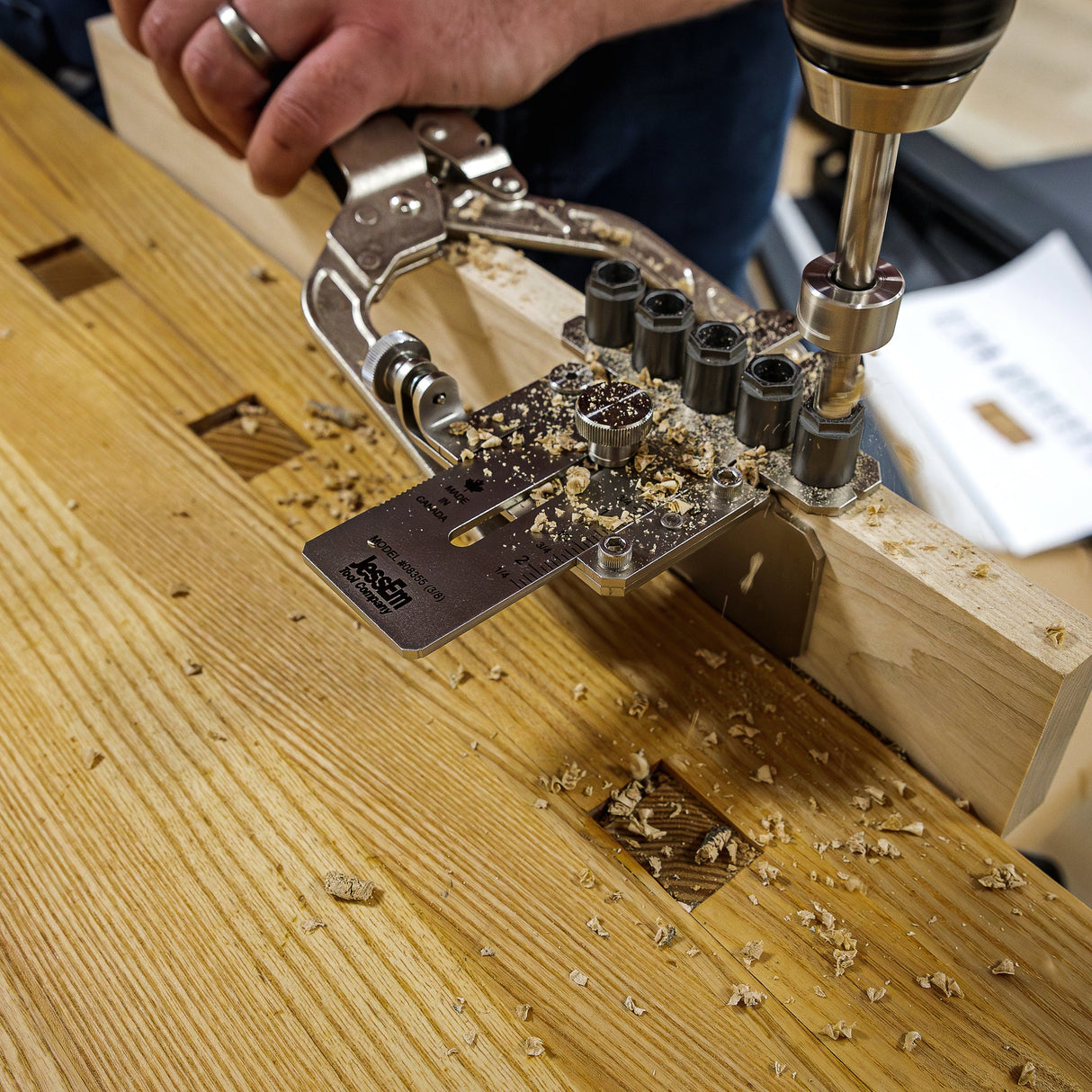 Woodworker using a drill and dowel jig on a benchtop for precision woodworking joinery