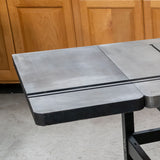 Close-up of cast iron router table wing extension with T-track slot in workshop setting