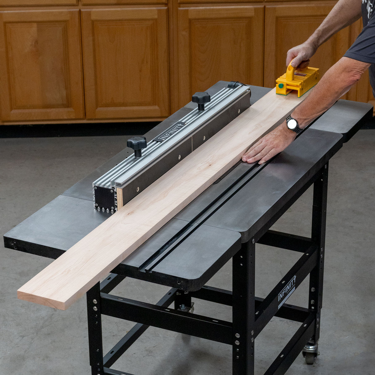 Cast iron router table wing extension in use for woodworking, cutting a wood board