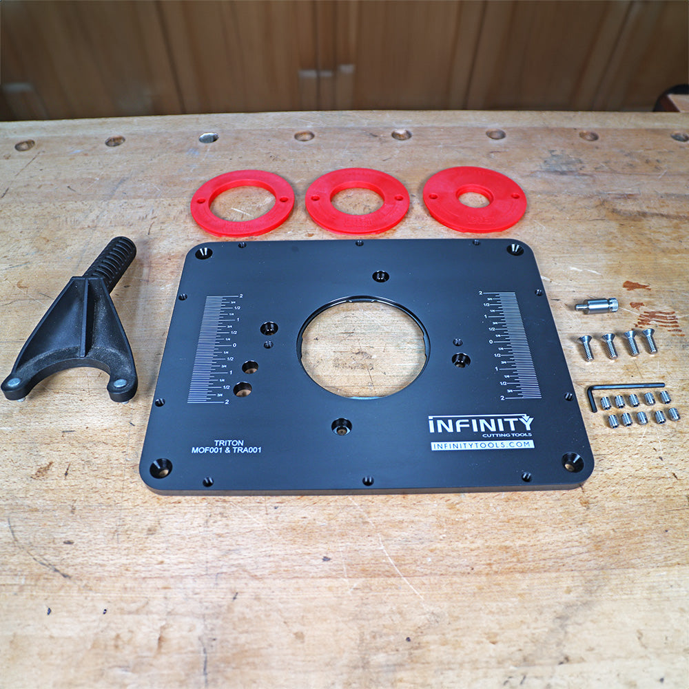 Router table insert plate kit with mounting hardware, rings, and wrench on workbench.