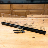 Shelf pin drilling jig with clear template and drill bits on a woodworking bench
