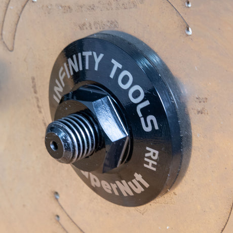 A close-up of the Infinity Tools SuperNut mounted on a table saw blade arbor.