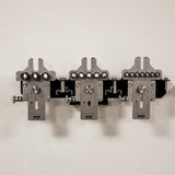 Precision metal woodworking jig set with drill guides and measurement markings mounted on wall