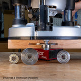 Slot cutter arbor installed in router cutting wood, with loose bearings and shims nearby.