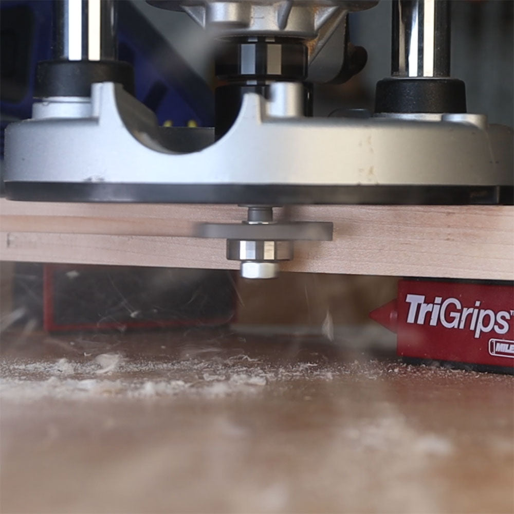 Slot cutter arbor attached to a router making a groove in a wood board, woodworking tool