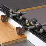 Woodworking table saw fence with dual featherboard hold-downs securing wood for precise cutting