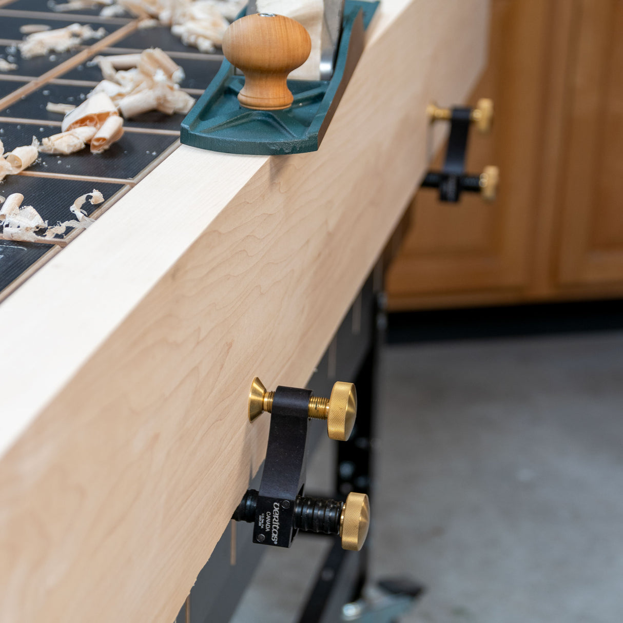 Veritas surface clamps holding a board on a side skirt while the board is being planed.