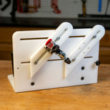 Adjustable vertical router sled jig on a woodworking bench, featuring slots and a clamp.