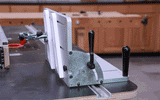 Adjustable woodworking table saw fence jig with handles on workbench in workshop
