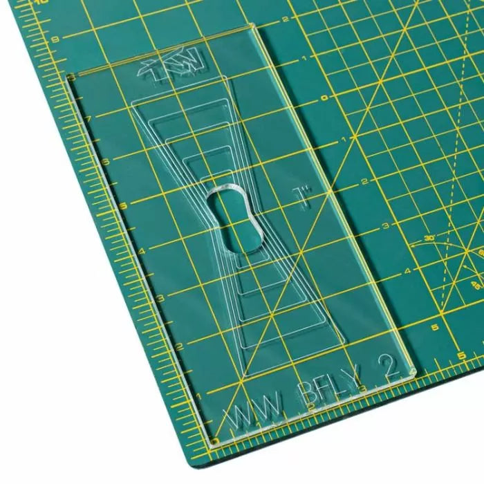 Acrylic woodworking template on green self-healing cutting mat with grid lines for precise measuring.