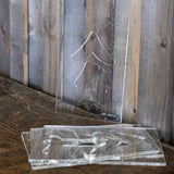 Acrylic woodworking templates with pine tree pattern on rustic wood surface