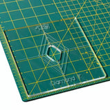 Acrylic diamond quilting template on a green cutting mat with yellow grid lines.