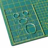 Clear acrylic teddy bear template on green self-healing cutting mat with measurement grid