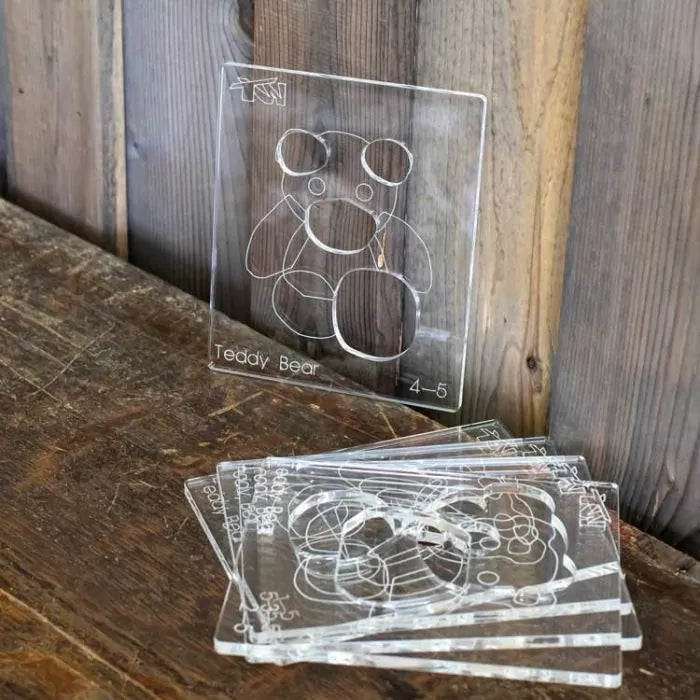 Clear acrylic teddy bear template stencils for woodworking on rustic table