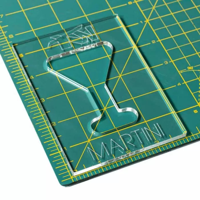 Acrylic martini glass template on a green cutting mat with yellow grid lines
