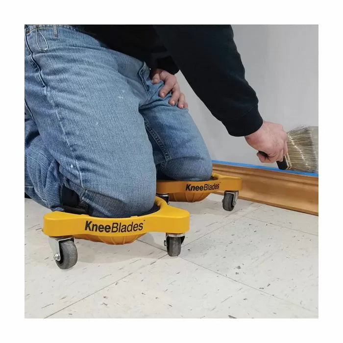 Person using yellow KneeBlades knee pads with wheels while painting baseboard trim