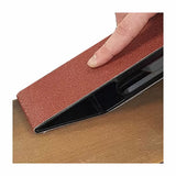 Hand using a sanding block to smooth a wooden surface, woodworking tool in action