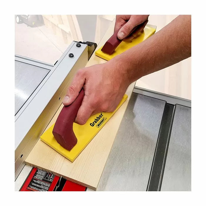 Woodworker using push blocks to guide wood on a table saw for safe, precise cutting.