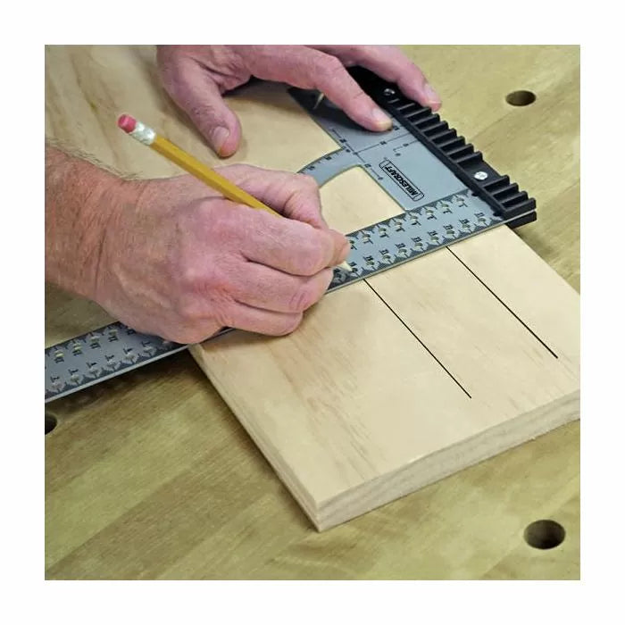 Woodworker using a T-square marking guide to draw precise lines on a wooden board