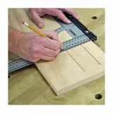 Woodworker using a T-square marking guide to draw precise lines on a wooden board