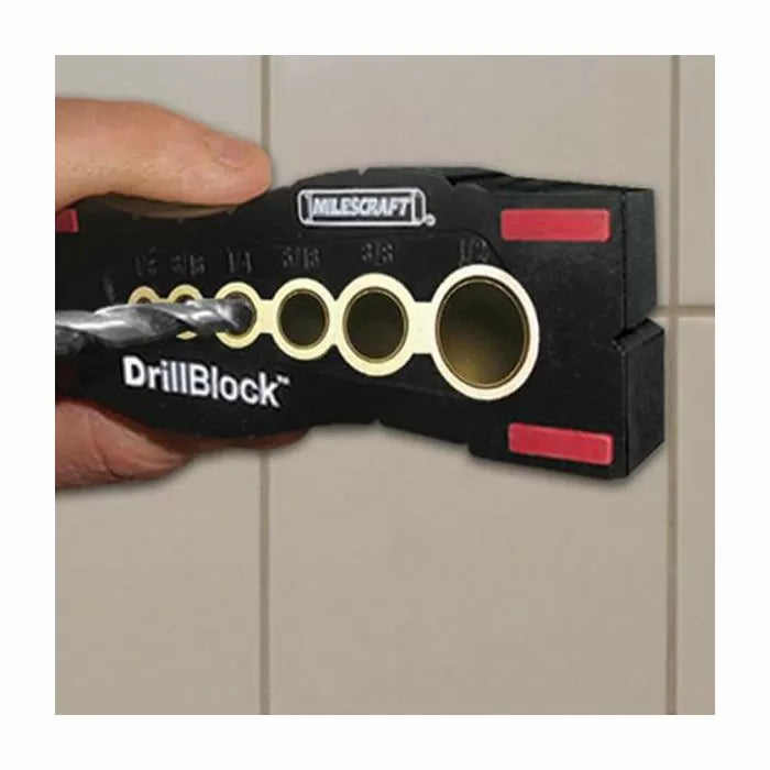 Hand holding a DrillBlock drill guide on tile wall for straight, precise drilling.