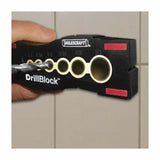 Hand holding a DrillBlock drill guide on tile wall for straight, precise drilling.