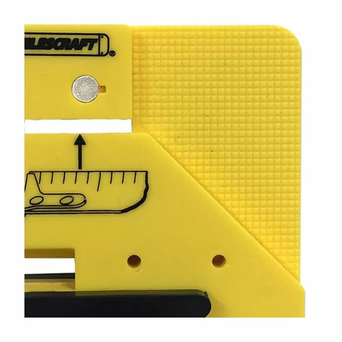Close-up of yellow woodworking marking jig with ruler graphic and textured surface