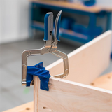 Corner clamp with blue handle securing wood boards for precise woodworking joints