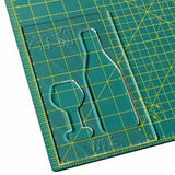 Acrylic wine bottle and glass template on green grid cutting mat for woodworking projects.