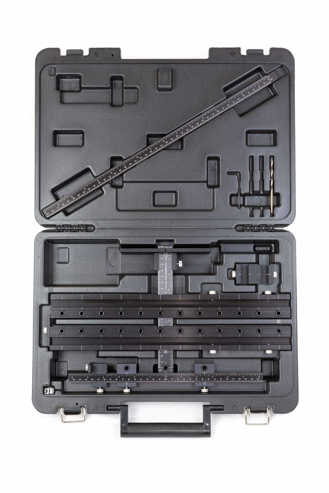 Woodworking dowel jig kit with ruler, drill bits, and guides in a hard plastic carrying case