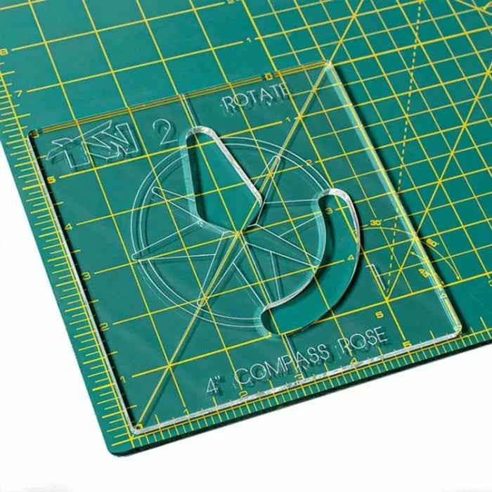 Acrylic compass rose template on a green gridded cutting mat for woodworking or crafts.