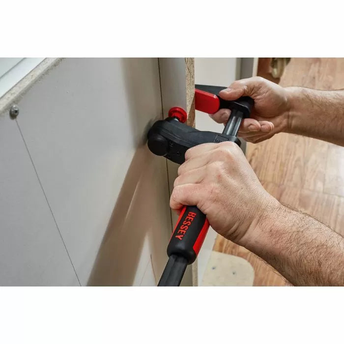 Woodworker using a BESSEY clamp to secure a panel during woodworking project