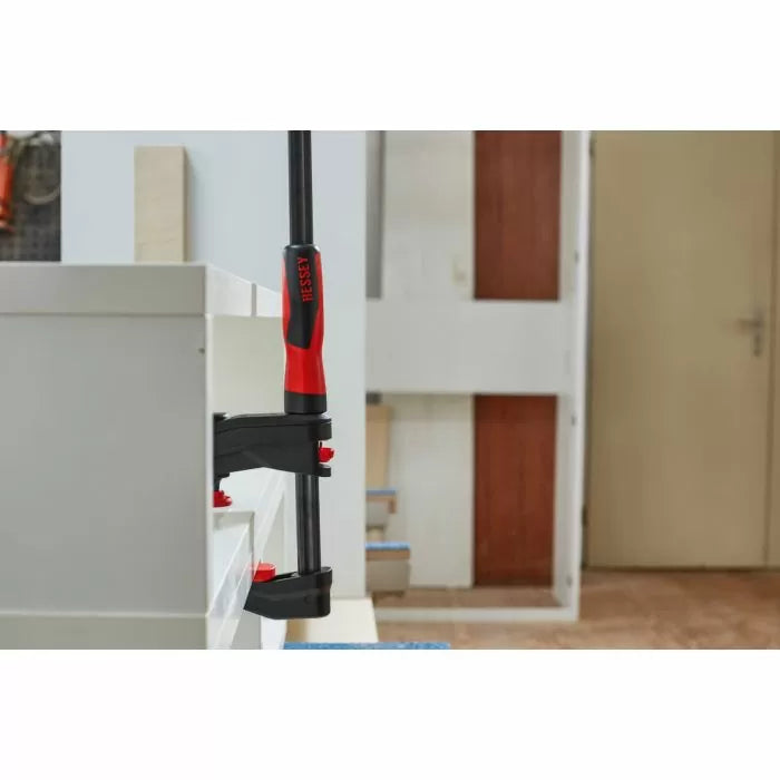 BESSEY woodworking clamp securing two boards in workshop setting
