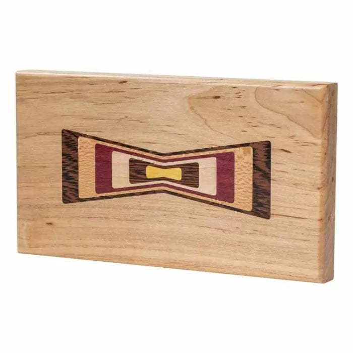 Rectangular wood inlay with colorful bowtie design on light hardwood, woodworking project