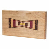 Rectangular wood inlay with colorful bowtie design on light hardwood, woodworking project