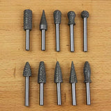 Ten rotary burrs for woodworking or metal shaping on a wooden surface, various shapes and sizes