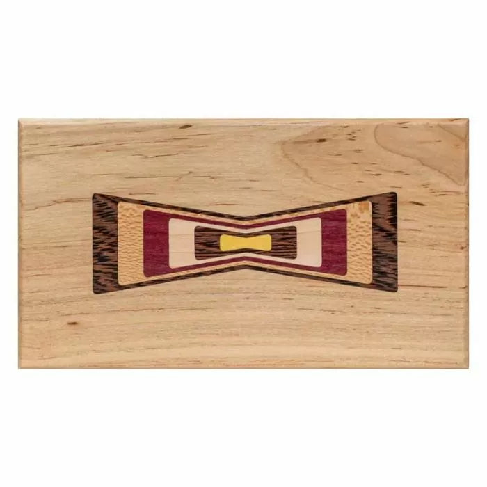 Woodworking inlay sample with multi-color bow tie design on a rectangular wooden board